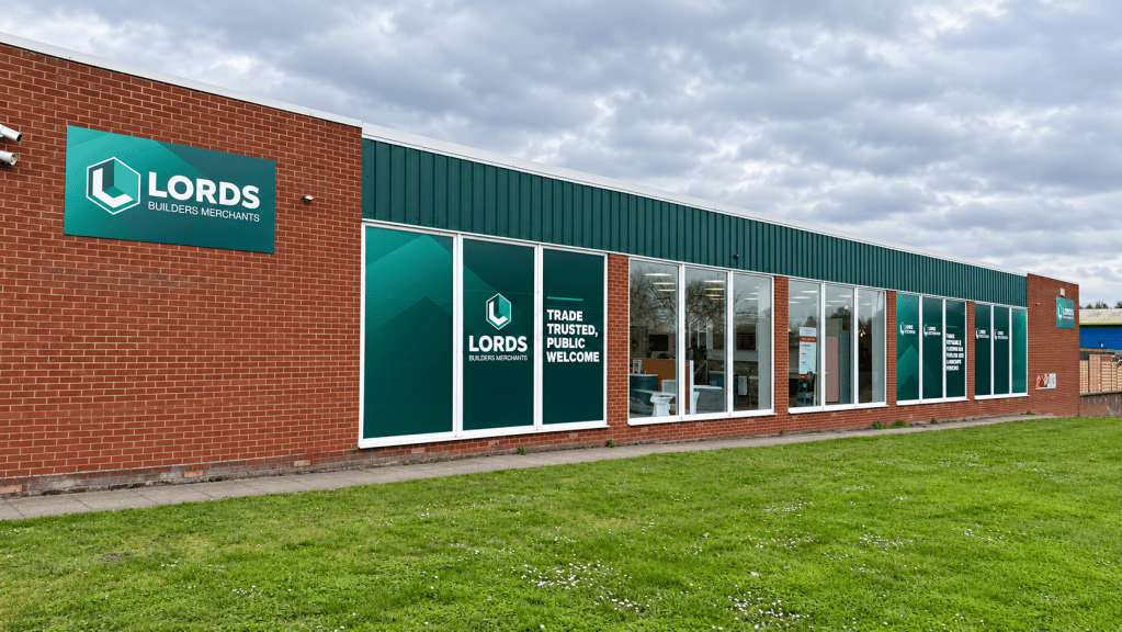 Lords Builders Merchants showroom exterior featuring large-format branded window graphics, exterior signage and “Trade Trusted, Public Welcome” messaging.